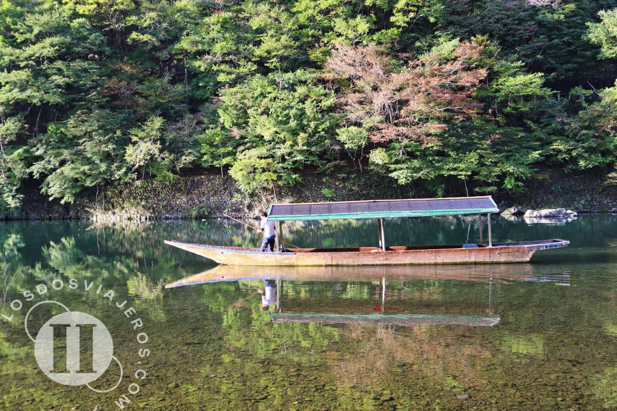 Barca reflejada en el agua del rio katsura, Kioto